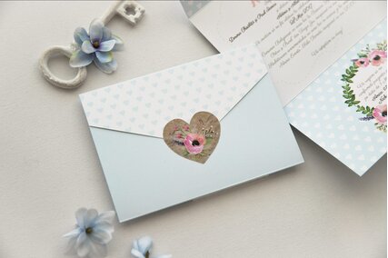 invitatie de nunta in forma de plic cu albastru pastel si inimioare si coronita de flori roz