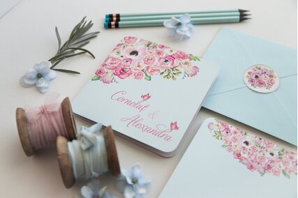 invitatie cu flori roz pictate in colt si plic albastru deschis