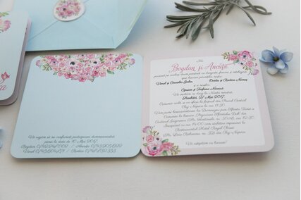 invitatie cu flori roz pictate in colt si plic albastru deschis