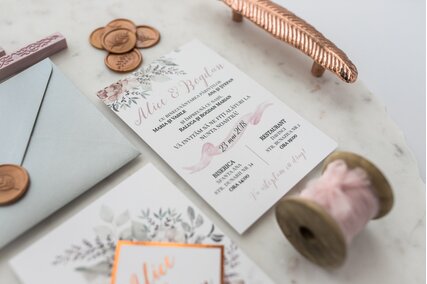 invitatie eleganta cu flori si verdeata cu text rose gold si banda geometrica aurie cu sigiliu